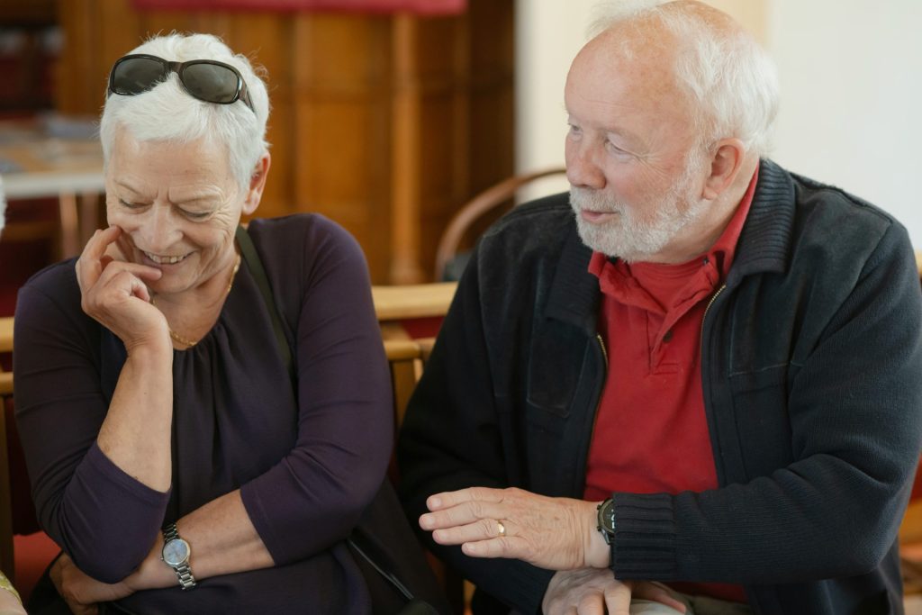 An older couple is talking and smiling.
